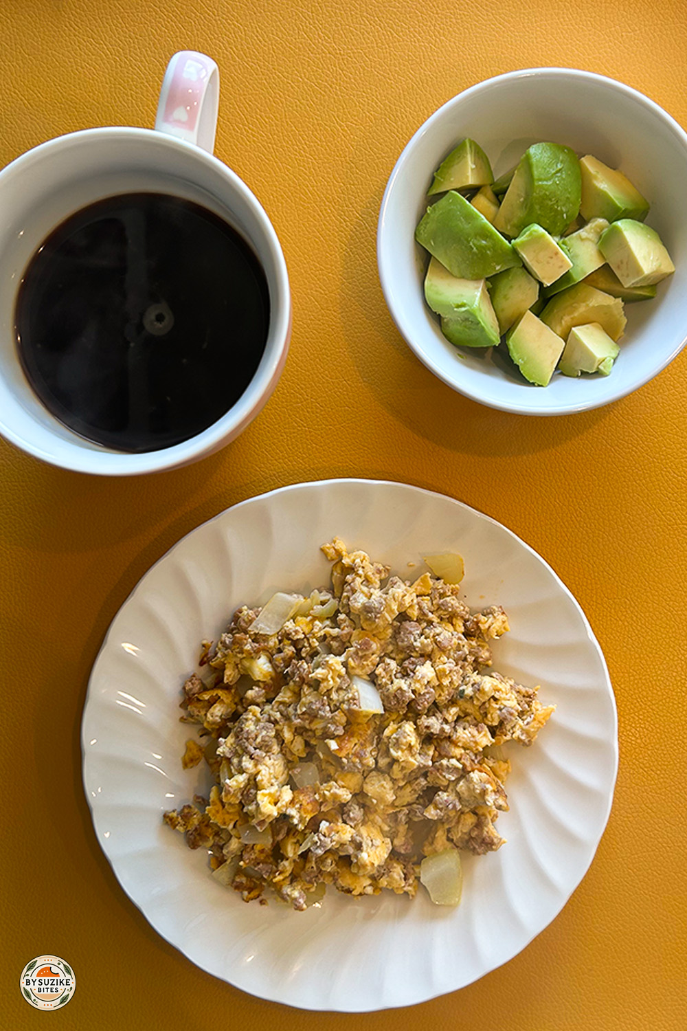 Low carb breakfast plate with scrambled eggs, ground beef, avocado and coffee