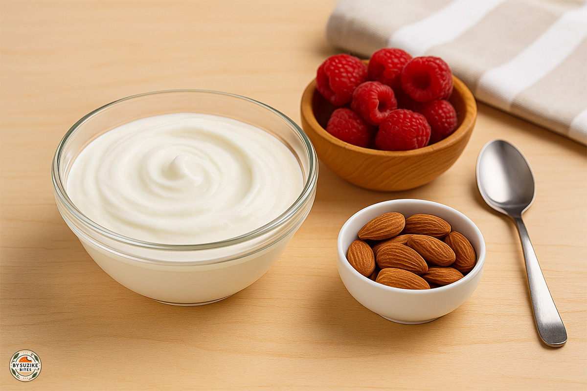 Greek Yogurt 3 Low carb snack with Greek yogurt, fresh raspberries, and almonds served on a wooden table.