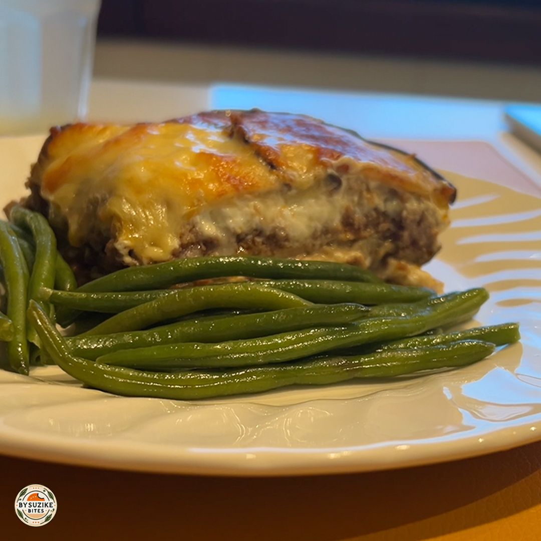 Keto eggplant lasagna with melted cheese, ground beef and green vegetables served as a low carb no-pasta dinner
