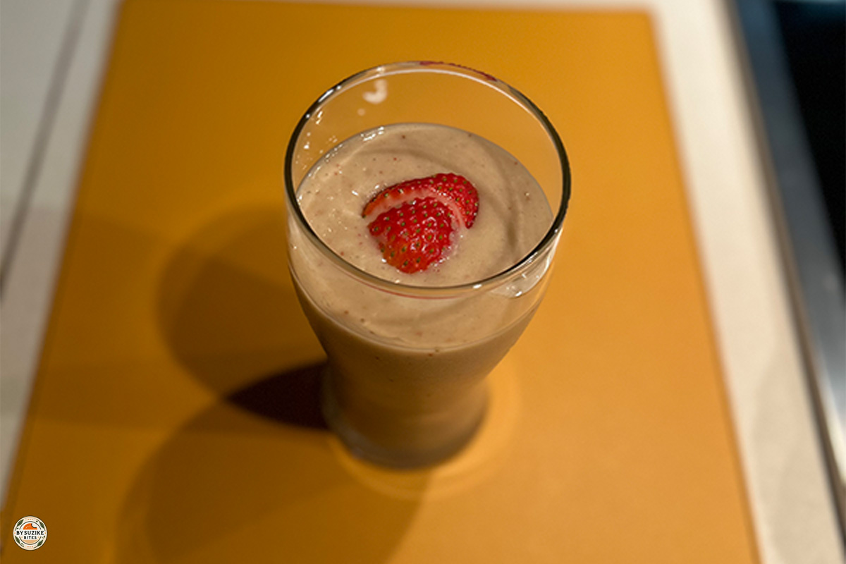 Glass of low carb strawberry avocado smoothie with a slice of strawberry on top