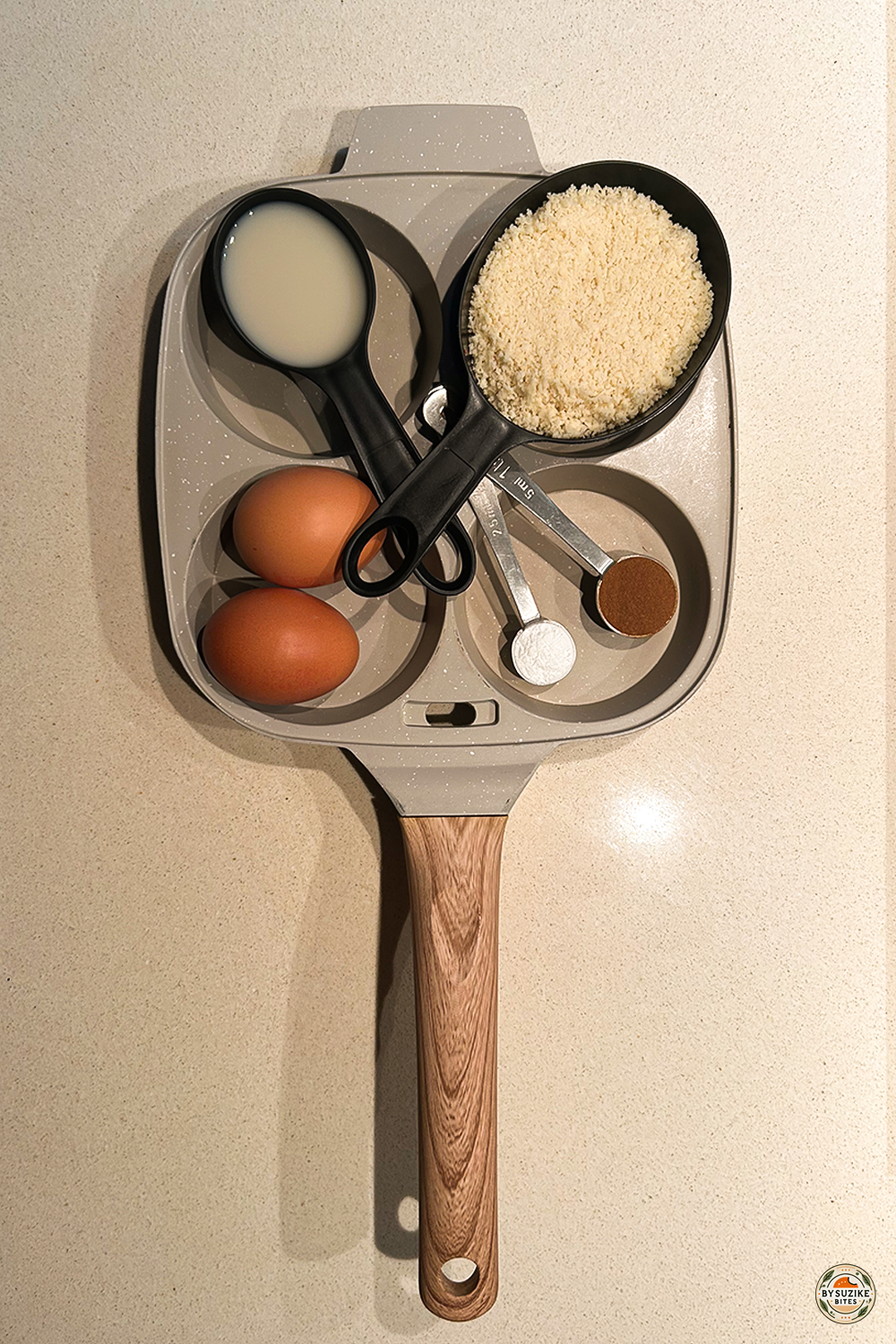 Nonstick egg pan with eggs, almond flour, and measuring cups ready for breakfast