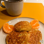 Oat and banana pancakes served with fresh tangerine and black coffee for a simple real-life breakfast - classic meals and recipes