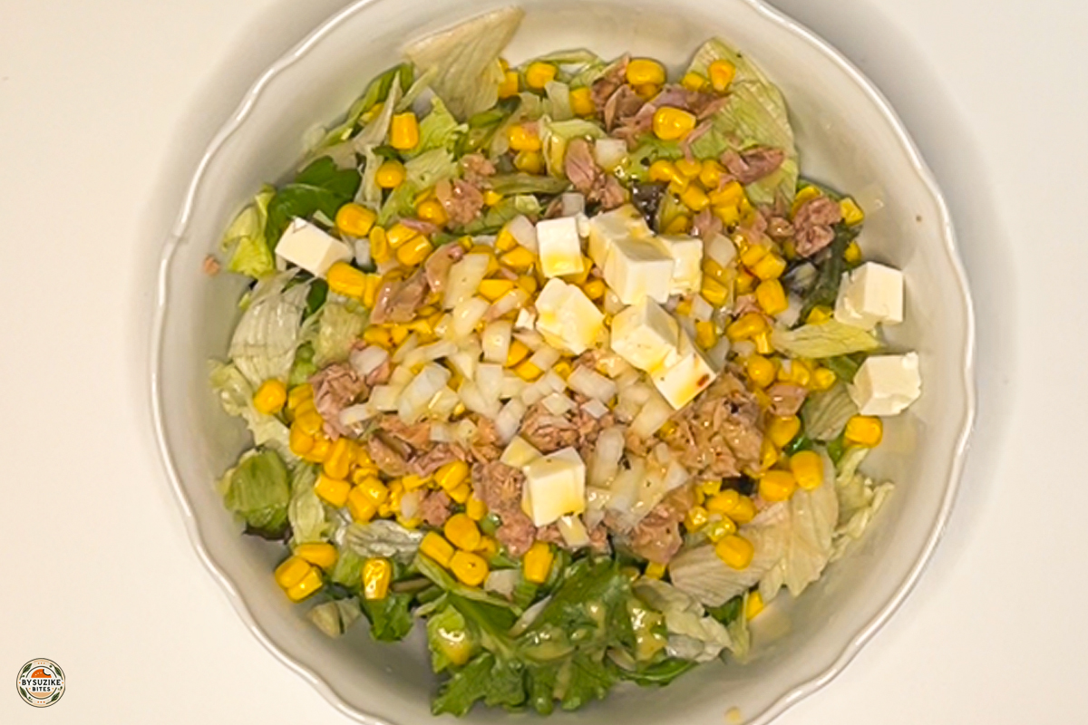 Close-up of creamy feta with crisp lettuce and corn for texture detail