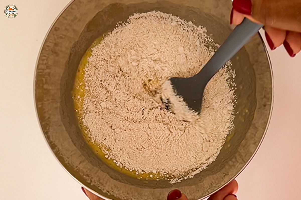 Oat Banana Cake 4 Mixing oats and dry ingredients in a bowl for banana oat cake
