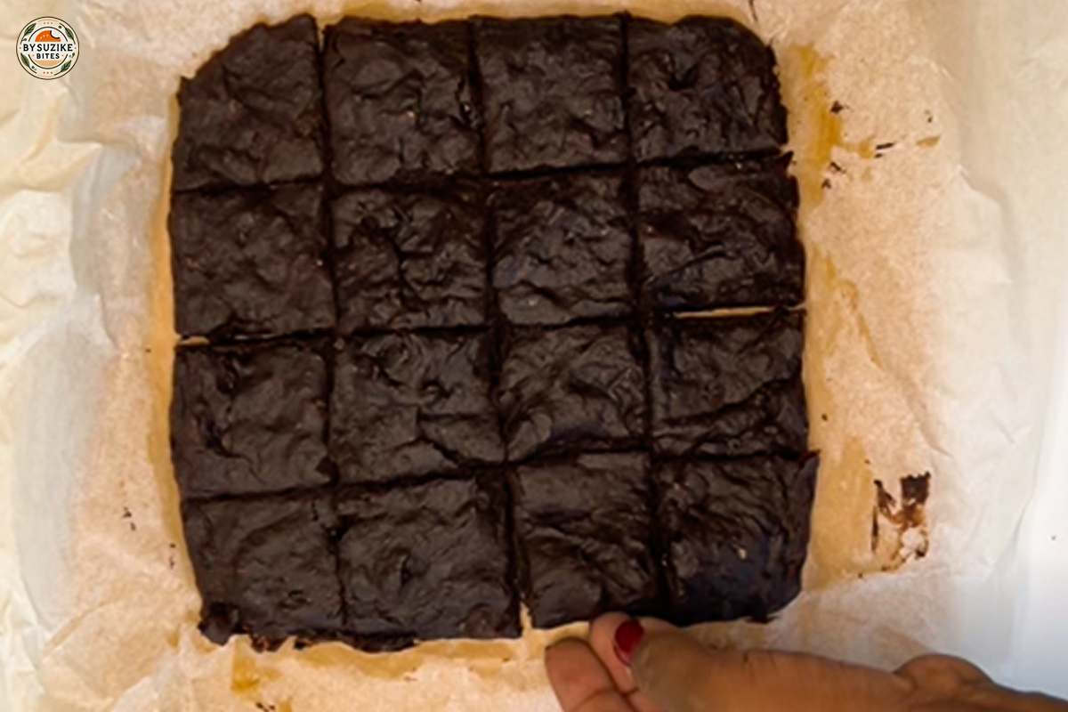 Freshly baked banana brownies being sliced in the pan