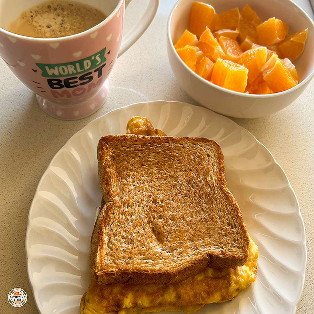 Whole wheat toast with eggs, a cup of coffee, and a bowl of orange pieces — simple, healthy breakfast idea for busy mornings.