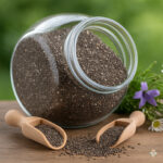 Chia seeds spilling from a glass jar with wooden scoop and wildflowers — a perfect low carb pantry essential.